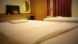 A hotel room with two beds, a television, a mirror, and a wooden wardrobe. - Le Luxe Residence (Udon Thani)