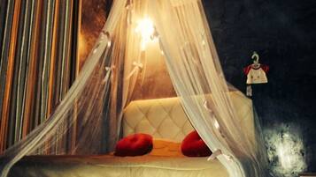 A bed with a canopy, red pillows, and a wall-mounted air conditioning unit.