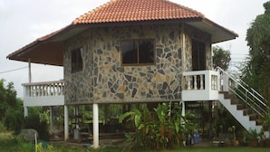 A two-story house with a stone facade and a red-tiled roof. - Ban Rim Nam Riverside Resort (Nan)