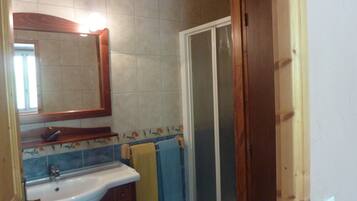 Un baño con lavabo, espejo y ducha.