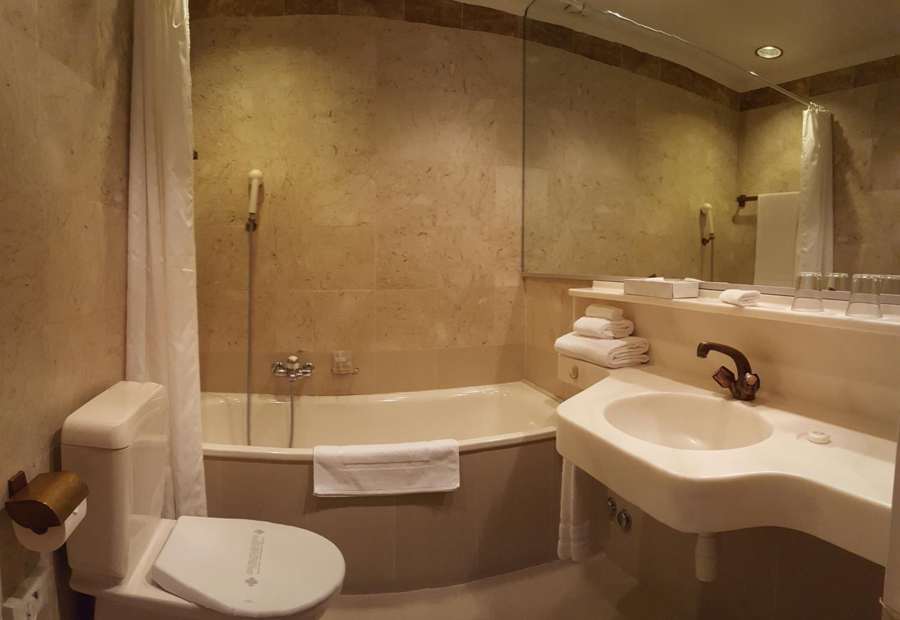 A modern bathroom with a bathtub, toilet, and sink.