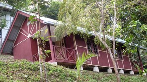 Un bâtiment doté d’un toit en pente et d’une façade rouge.