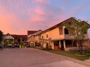 A two-story building with a red-tiled roof, multiple balconies, and string lights. - Phaythavone Hotel (Pakse)