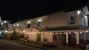 Un bâtiment doté d’une terrasse et illuminé de guirlandes lumineuses.