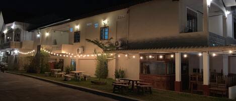A building with outdoor seating and string lights.