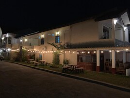 A building with outdoor seating and string lights.