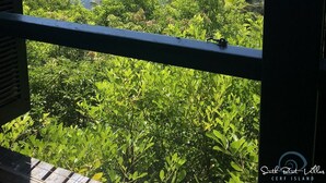A view of the ocean from a window with lush greenery in the foreground. - South Point Villas (Cerf Island)