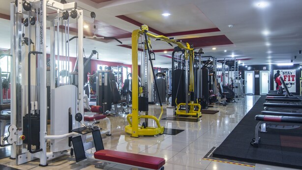 A gym with various exercise machines, a bench, and a mirrored wall. - Super OYO Capital O 804 Hotel Pinji (Ipoh)