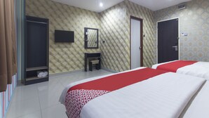 A hotel room with two beds, a vanity with a mirror, a wardrobe, and a television. - Super OYO Capital O 804 Hotel Pinji (Ipoh)
