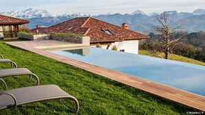 A poolside area with lounge chairs, a wooden deck, and a view of mountains. - Puebloastur Eco-Resort Wellness & Spa (Parres)