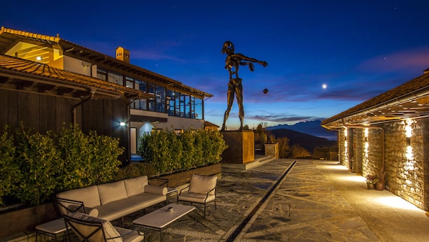 An outdoor patio with stone flooring, a seating area, and a statue. - Puebloastur Eco-Resort Wellness & Spa (Parres)