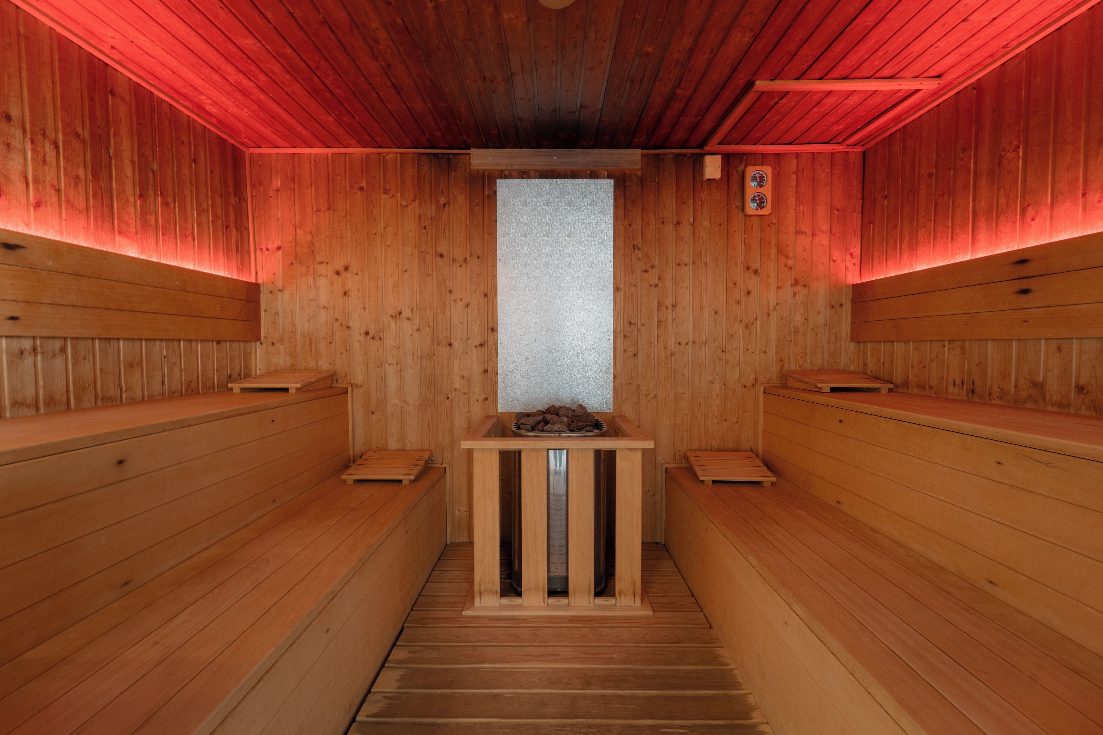 Una sauna con bancos de madera y un pilar central.