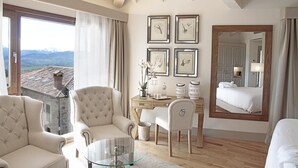 A hotel room with a large window, a wooden desk, a comfortable seating area, and a bed. - Puebloastur Eco-Resort Wellness & Spa (Parres)