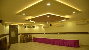 A conference room with a long table covered by a pink tablecloth, wooden chairs, and recessed lighting on the ceiling. - FabHotel Padmavati Palace Mansarovar (Jaipur)