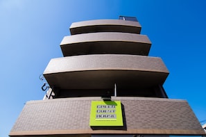 A multi-story building with a sign reading "GREEN GUEST HOUSE". - Green Guest House Kagoshima - Hostel (Kagoshima)