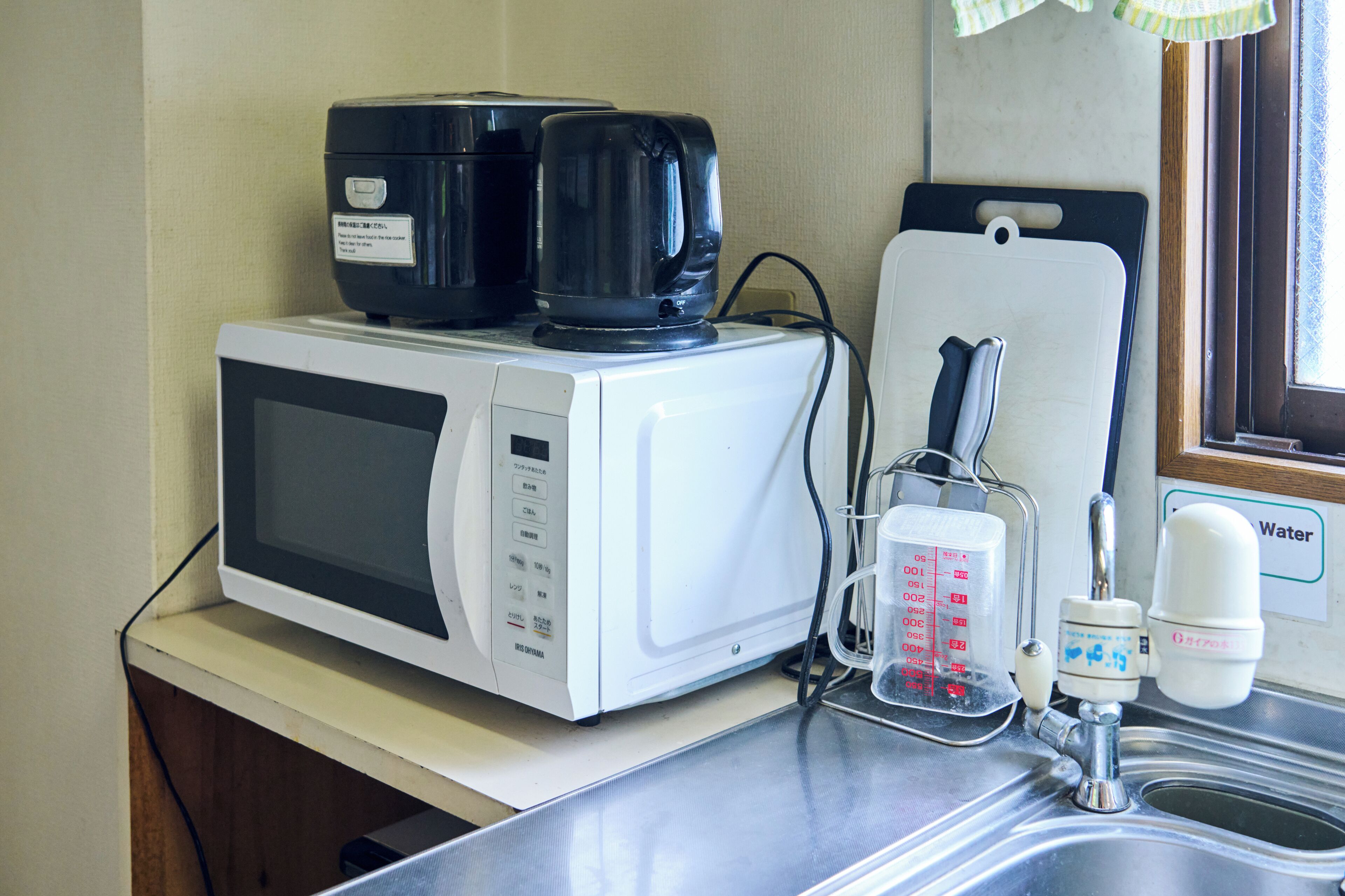 A kitchen with a microwave, coffee maker, and water dispenser.