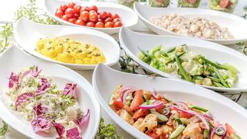A variety of dishes on white oval plates, including salads and a dish with cauliflower.