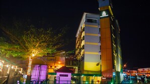 Un hotel de varios pisos con un diseño moderno, que presenta un elemento vertical destacado a la derecha.