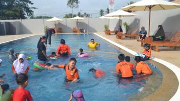 Guests can enjoy a refreshing swim in the pool surrounded by lounge chairs and umbrellas.
