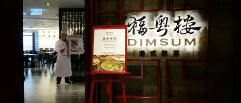 A restaurant interior with a sign reading "DIMSUM" and a menu board.