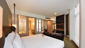 A hotel room with a large bed, a sofa, a desk, and a bathroom visible through an open door. - Fullon Hotel Taoyuan Airport Access MRT A8 (Taoyuan City)