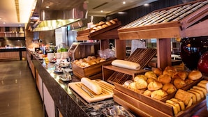 A buffet area with various baked goods and bread displayed on wooden stands. - Fullon Hotel Taoyuan Airport Access MRT A8 (Taoyuan City)
