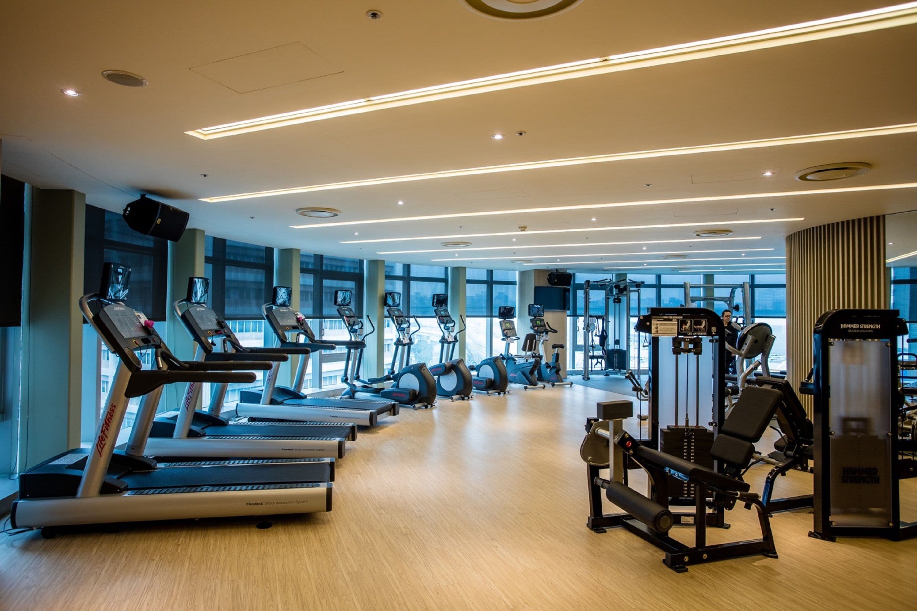 Een sportschool met loopbanden, elliptische trainers en gewichten.