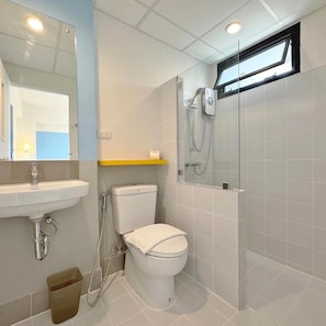 A bathroom with a toilet, sink, and shower.