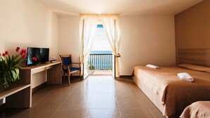 A hotel room with a bed, a desk with a TV, a chair, and a balcony with a view of the sea. - Hotel Stella Maris Terme & Beauty (Casamicciola Terme)