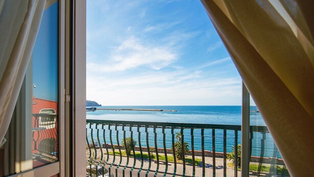 A balcony with a view of the sea and a distant island. - Hotel Stella Maris Terme & Beauty (Casamicciola Terme)