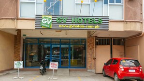 A hotel entrance with a sign indicating reserved parking for guests.