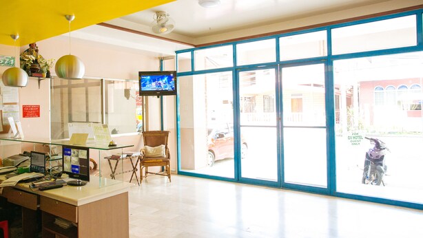 A reception area with a desk, computer, and a television.