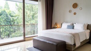 Un dormitorio con un ventanal grande, una cama, una mesita de noche y vistas al verdor exterior.