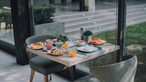 A breakfast table with plates of food, a coffee cup, and a glass of orange juice. - Serenity Hotel Spa & Onsen (Kabin Buri)