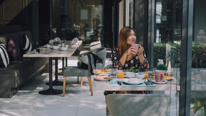A modern dining area with a table set for breakfast, including plates of food, a coffee cup, and a glass of orange juice. - Serenity Hotel Spa & Onsen (Kabin Buri)