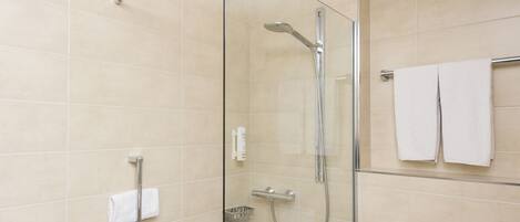 A modern bathroom with a glass-enclosed shower, a towel rack, and a control panel.