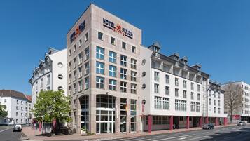 Un hotel a più piani con un evidente cartello 'HOTEL FULDA', ampie finestre e un design architettonico moderno.