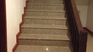 A staircase with wooden handrails and carpeted steps. - Chalouvanh Hotel (Pakse)