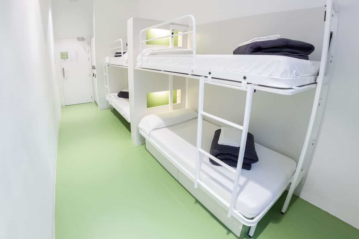 Una habitación con literas, una puerta y un suelo verde.
