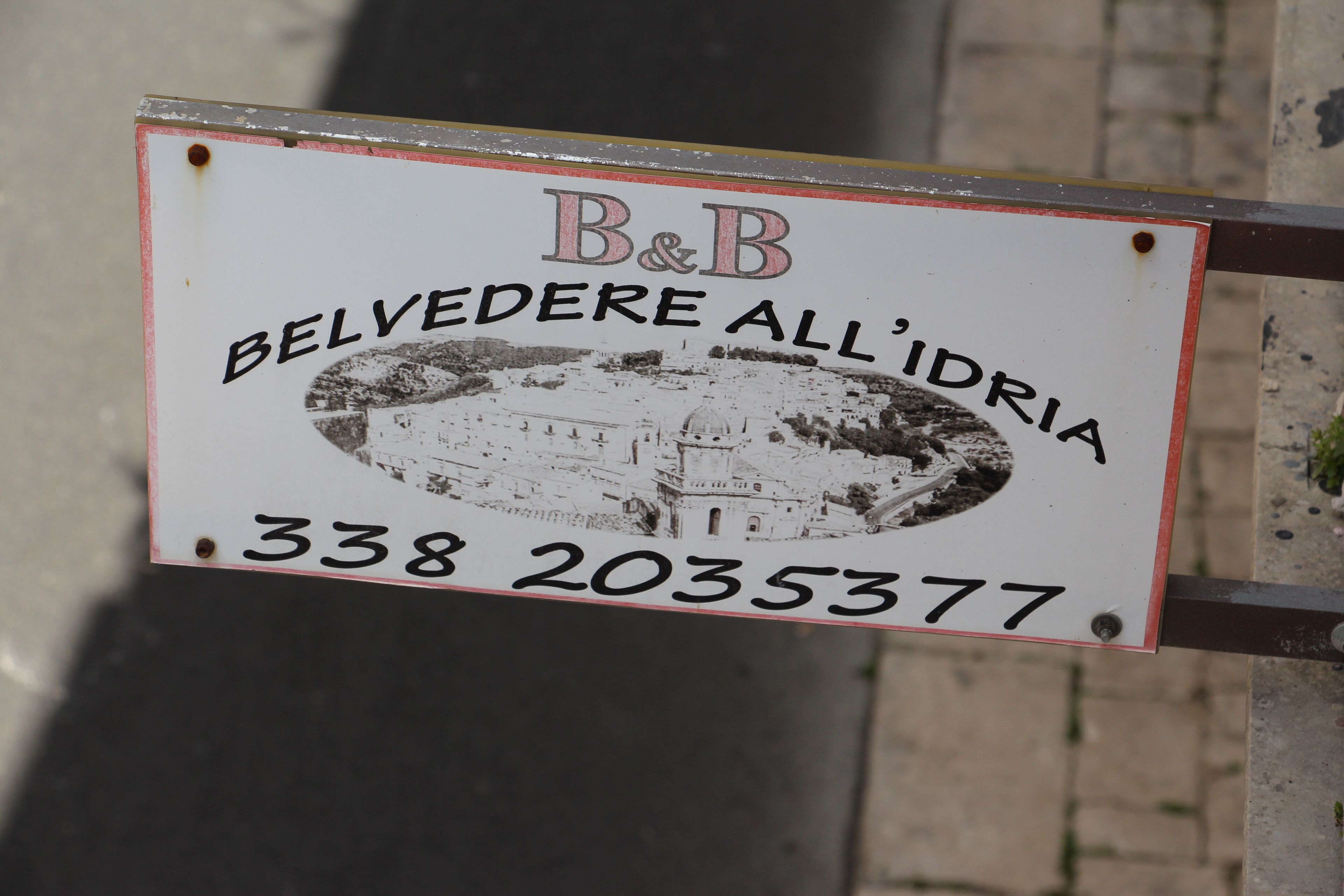 A sign with the text "B&B BELVEDERE ALL'IDRIA" and a phone number "338 2035377".