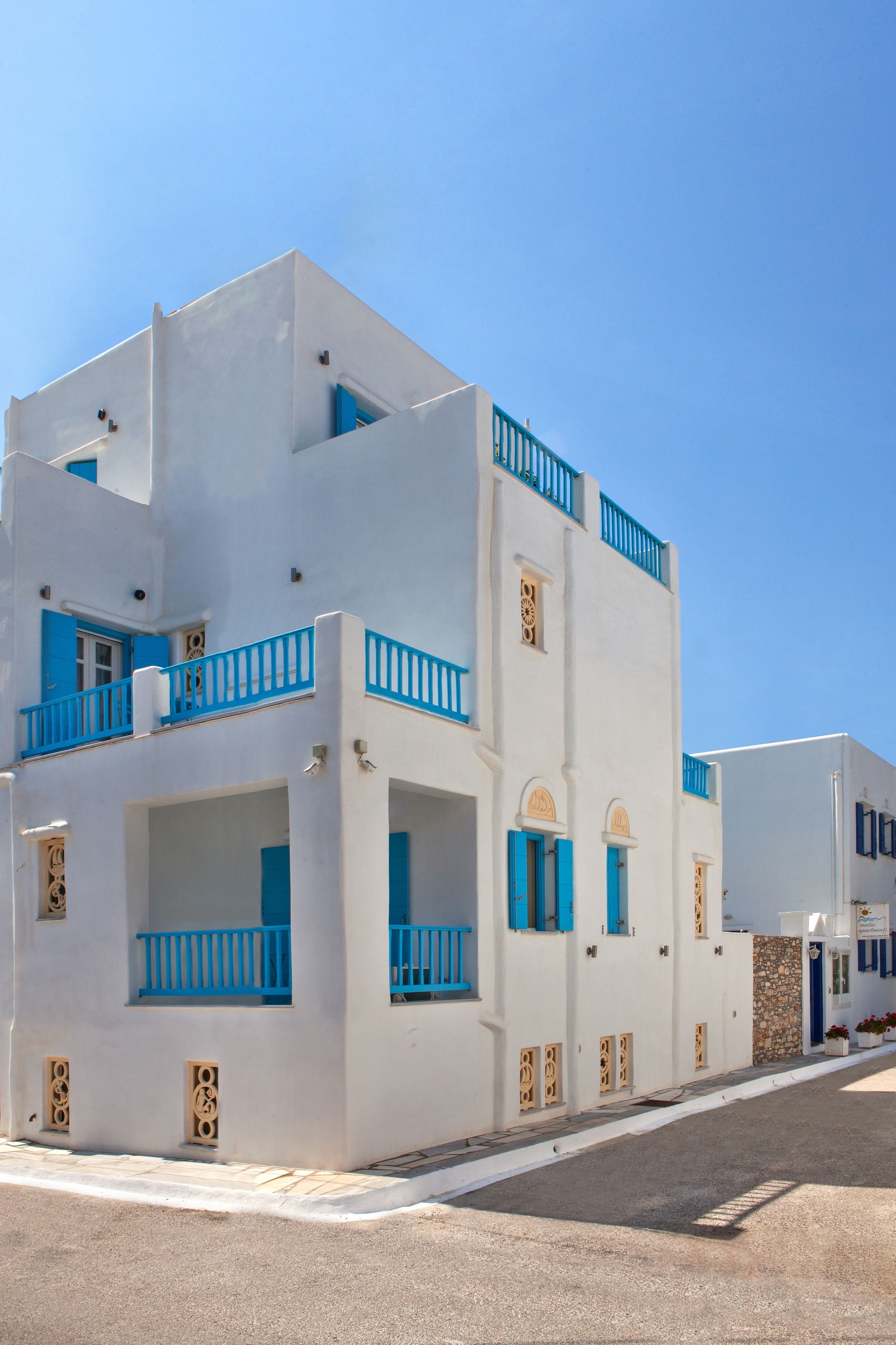 A white building with blue accents and balconies.