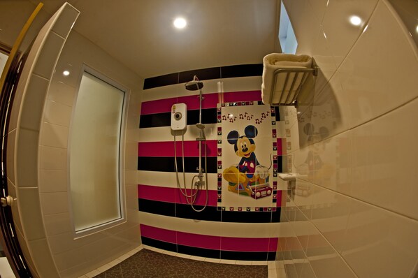 Un baño con un mural de Mickey Mouse, una ducha y un perchero para toallas.