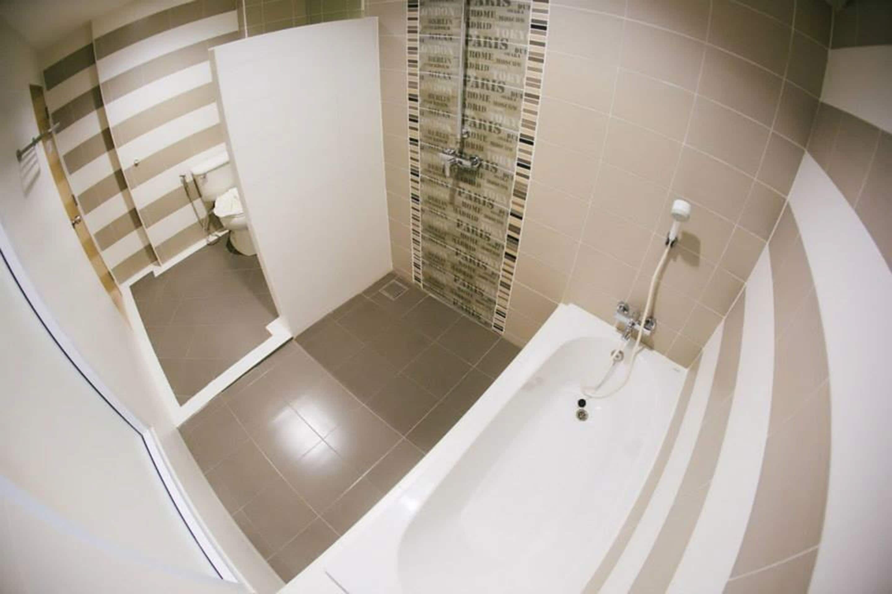 A bathroom with a bathtub, a toilet, and a shower area.