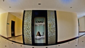A hotel entrance with a sign reading "OMG PLACE" and a person sitting on a cloud. - OMG Hotel (Khon Kaen)