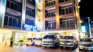 A multi-story hotel with a sign reading "OMG HOTEL" and several parked cars in front. - OMG Hotel (Khon Kaen)
