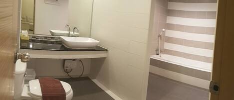 A bathroom with a toilet, sink, and shower.