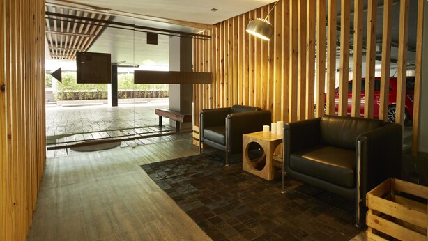 Un interior moderno con listones de madera, sofás de cuero y una mesa de centro de madera.