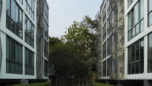 Un edificio moderno con un patio central que presenta una piscina rectangular.