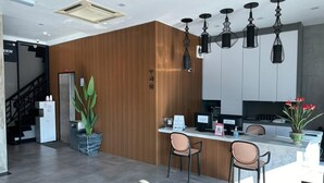 Une cuisine moderne avec un mur d’accent en bois, un îlot central doté de tabourets de bar et un éclairage suspendu.