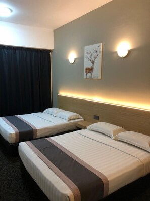 A hotel room with two single beds, a headboard with integrated lighting, a wall-mounted picture of a deer, and a dark curtain. - Greenlast Hotel (Kuantan)